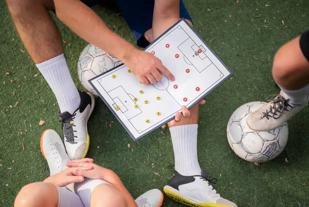 Voetbalcoach geeft uitleg aan kinderen