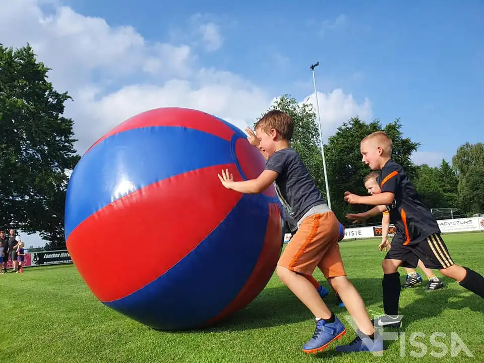 Drie jongens rennen achter Big Ball aan