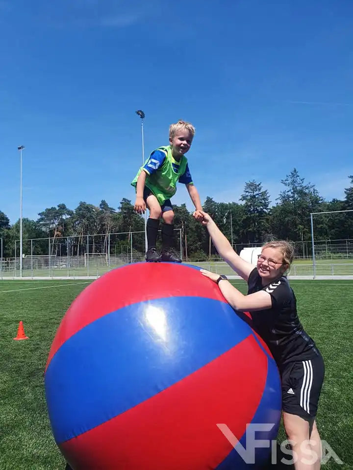Kind bovenop grote ballen (Big Balls) bij Sport en Spel activiteit