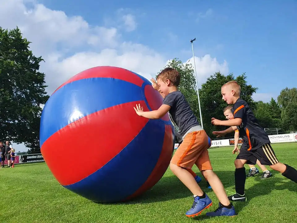 Kinderen spelen met Big Balls (grote ballen) bij BSO activiteit